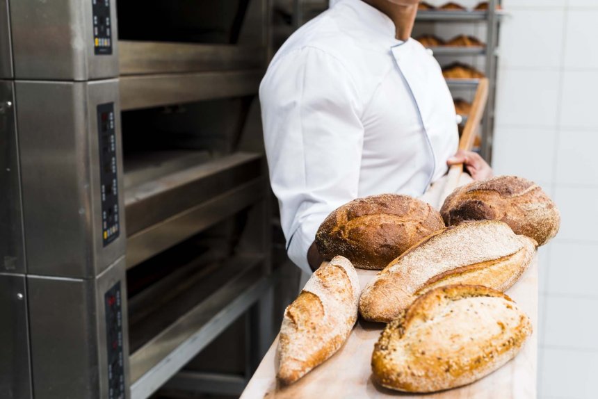 close-up-male-baker-holding-fresh-baked-bread-wooden-shovel-from-oven.jpg